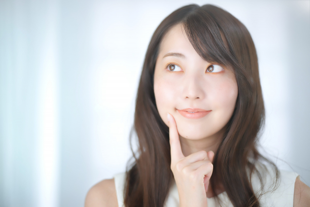 頬に指を当てる女性